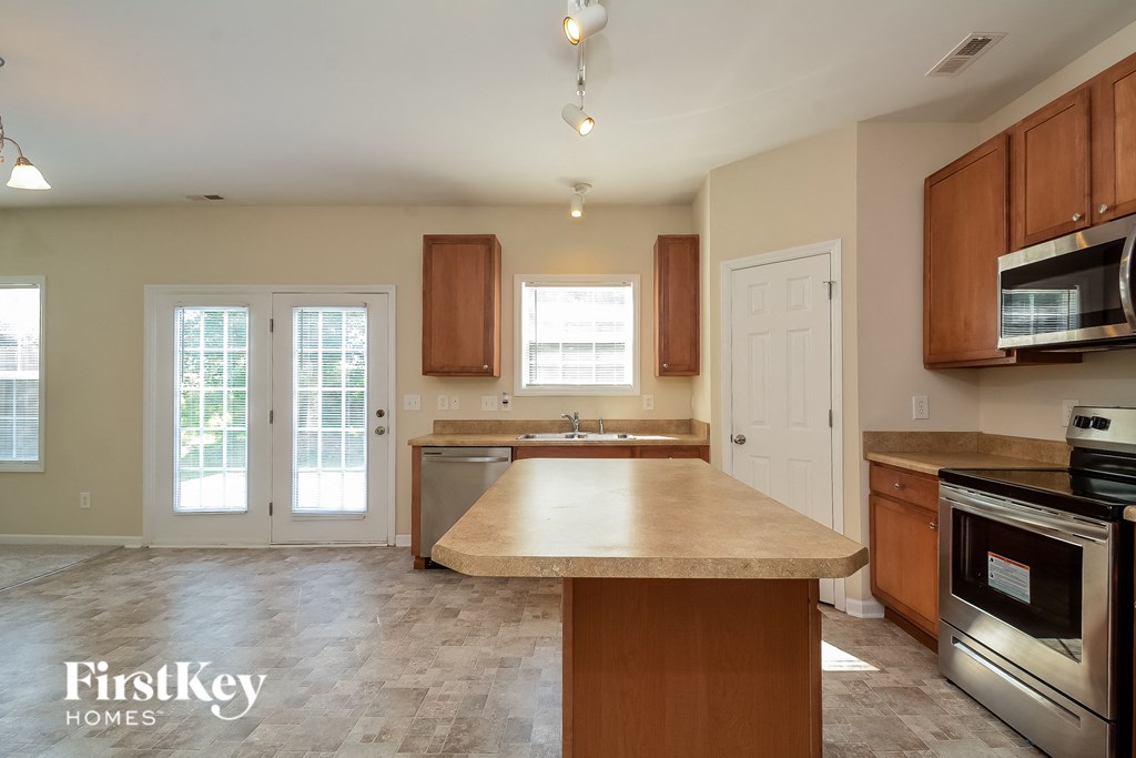 an empty kitchen with a large island in the center