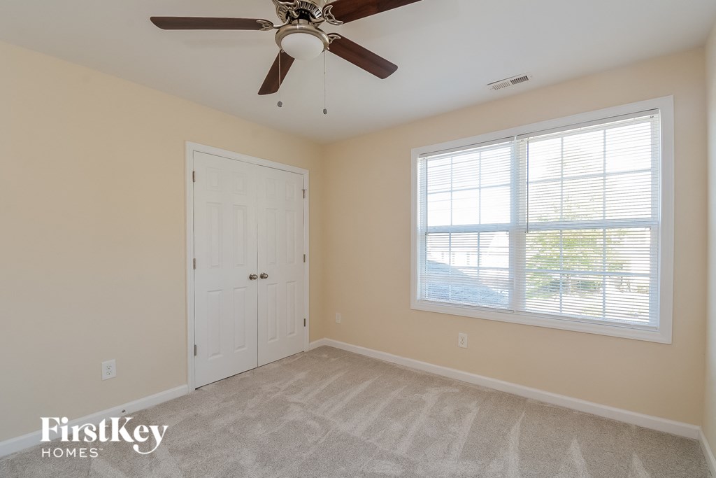the living room of a home with a ceiling fan and a window