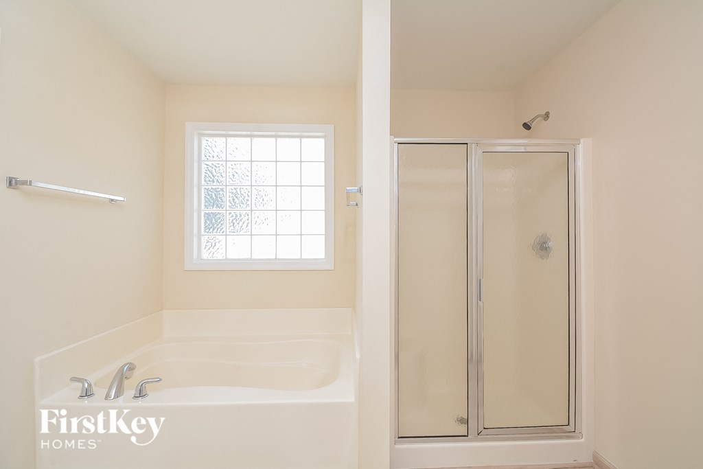 a bathroom with a tub and a shower and a window