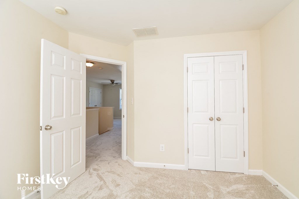 a bedroom with two closets and a hallway with a door to the bathroom and