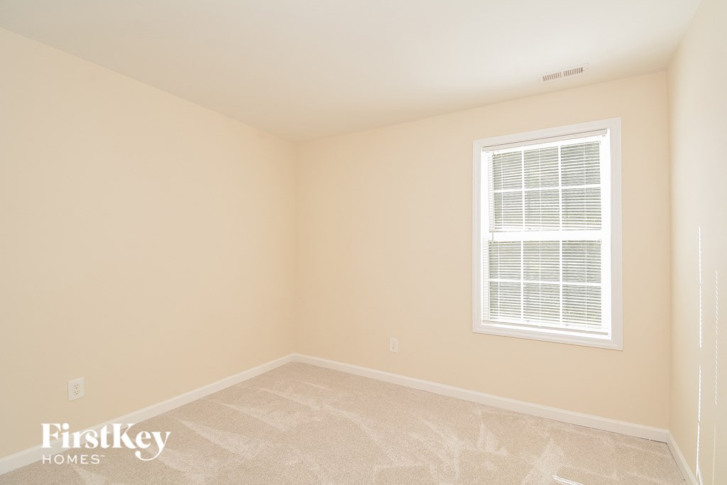 a bedroom with a window and a tiled floor