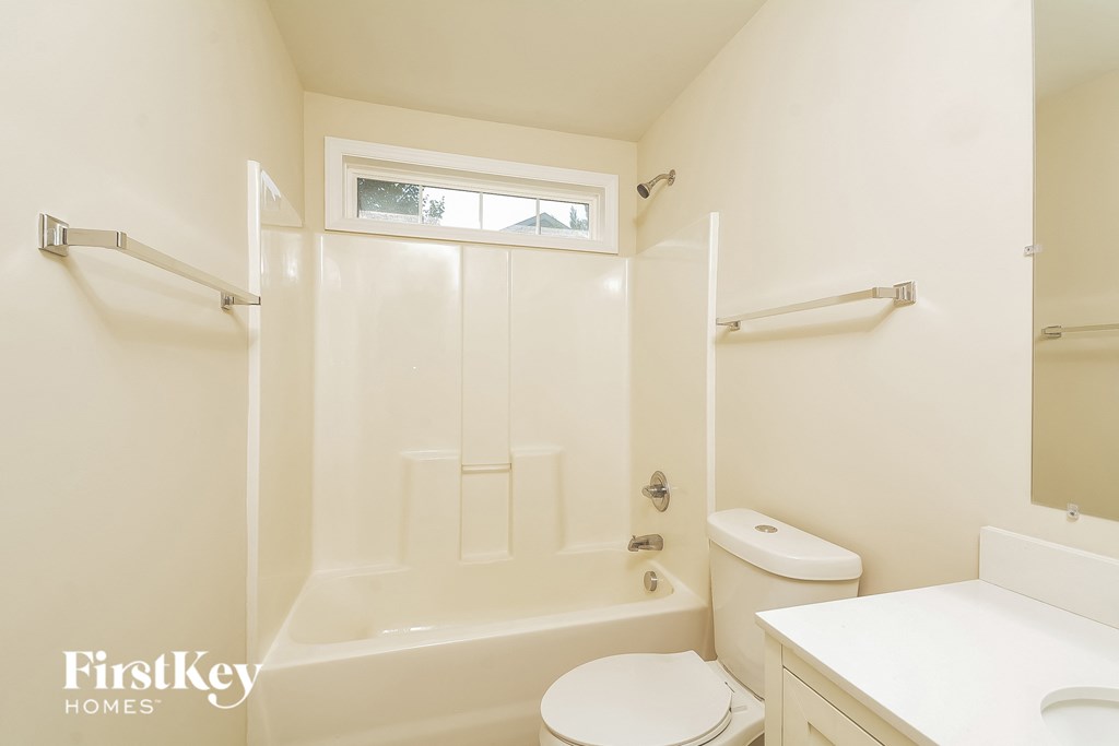 a bathroom with a shower and a toilet and a sink