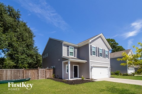 A grey house with the words "FirstKey Homes" on the lawn.