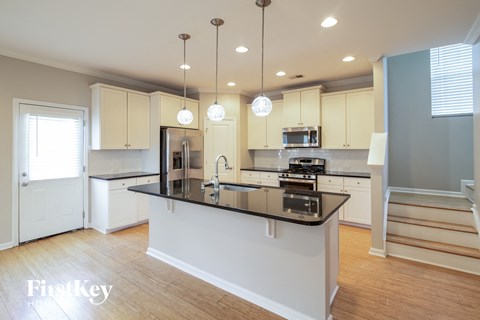 A kitchen with a black counter top and white cabinets.