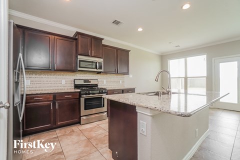 a kitchen with a marble counter top and wooden cabinets