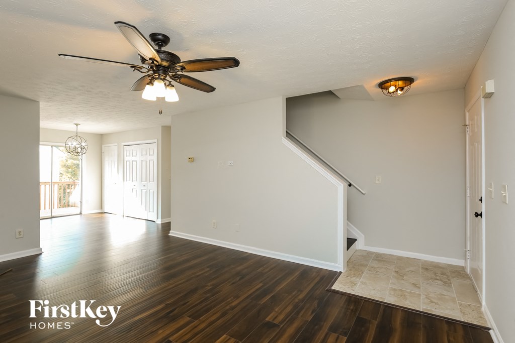 A spacious room with wooden floors and a ceiling fan.