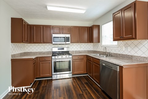 A kitchen with brown cabinets and a stainless steel dishwasher.