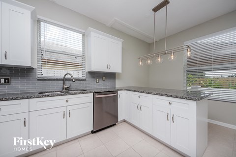 a white kitchen with white cabinets and stainless steel appliances