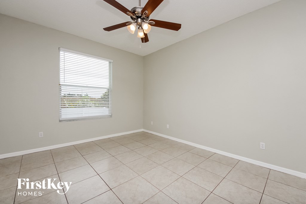 a living room with a ceiling fan and a tiled floor