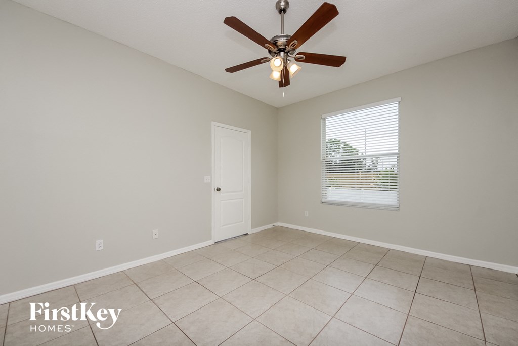 a living room with a ceiling fan and a tiled floor