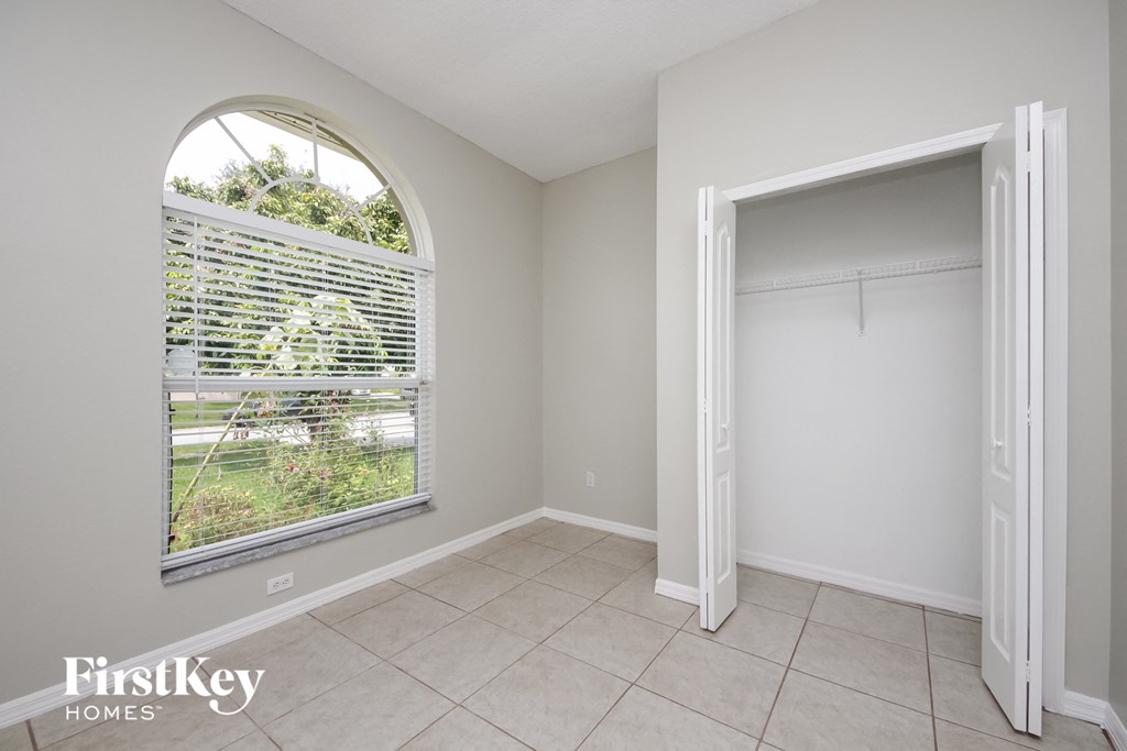 an empty room with a large window and a closet