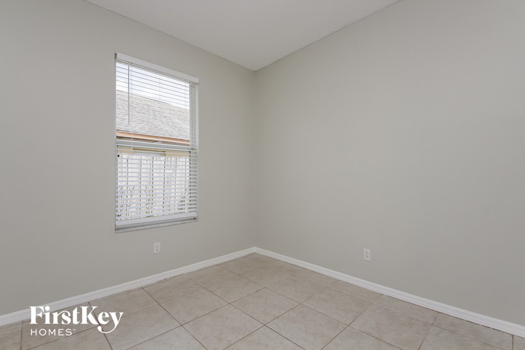 an empty room with a window and a tiled floor