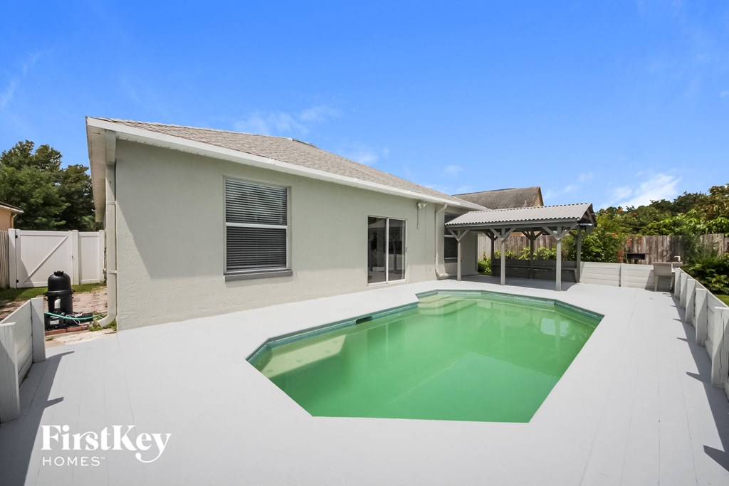 a backyard with a pool and a house
