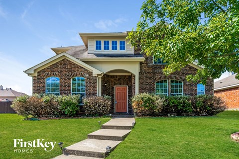 a home with a red front door and green grass