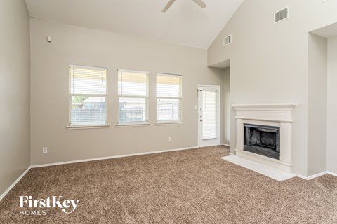 the living room has a fireplace and carpeted flooring