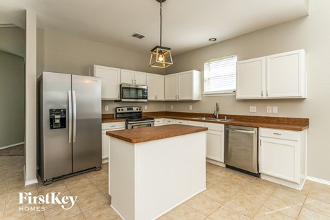 a large kitchen with stainless steel appliances and white cabinets