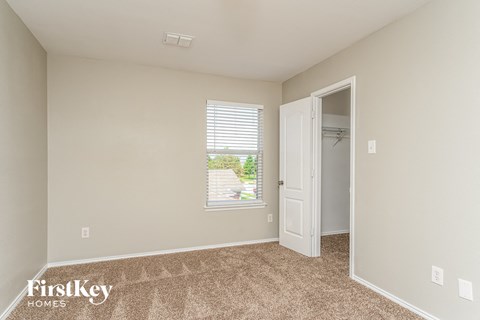 a bedroom with a door to a closet and a window