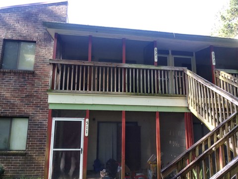 the front of a house with a wooden balcony