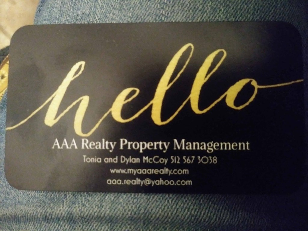 A black and gold business card for AAA Realty Property Management.
