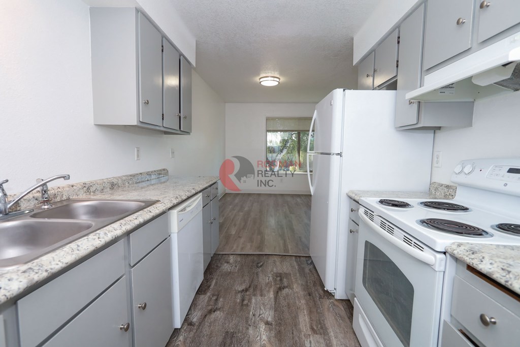 A kitchen with white appliances and cabinets.