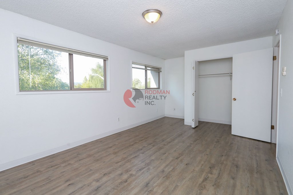 A room with a white wall and a wooden floor.