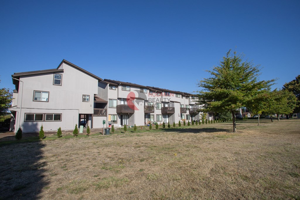A large white building with a red sign on the side.