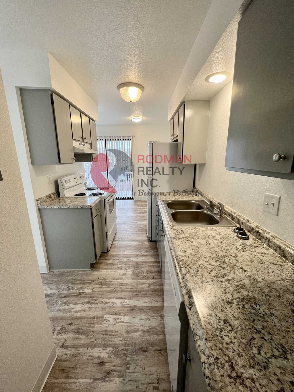 A kitchen with a sink and a countertop with a granite countertop.