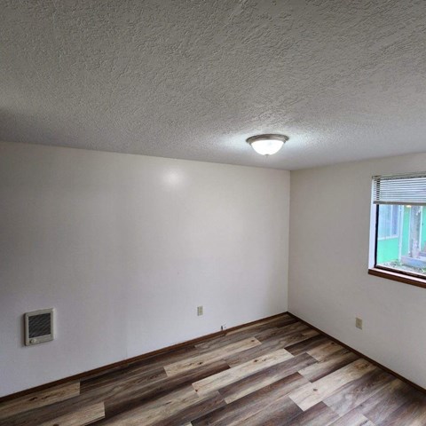 A room with wooden floors and a window.