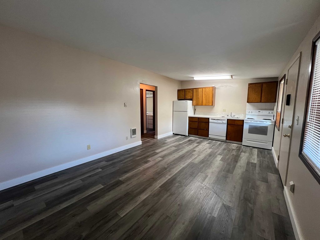 A kitchen with white appliances and wooden cabinets.