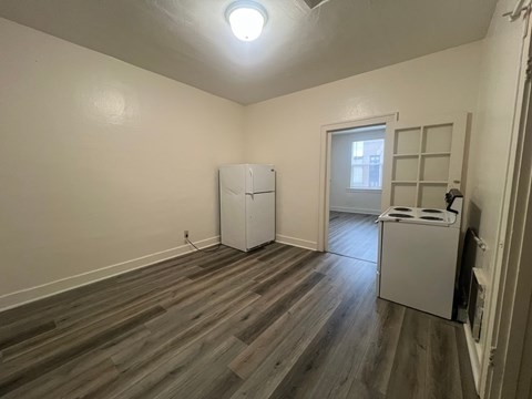 a kitchen and living room with a refrigerator and a stove