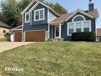 a blue house with a lawn in front of it