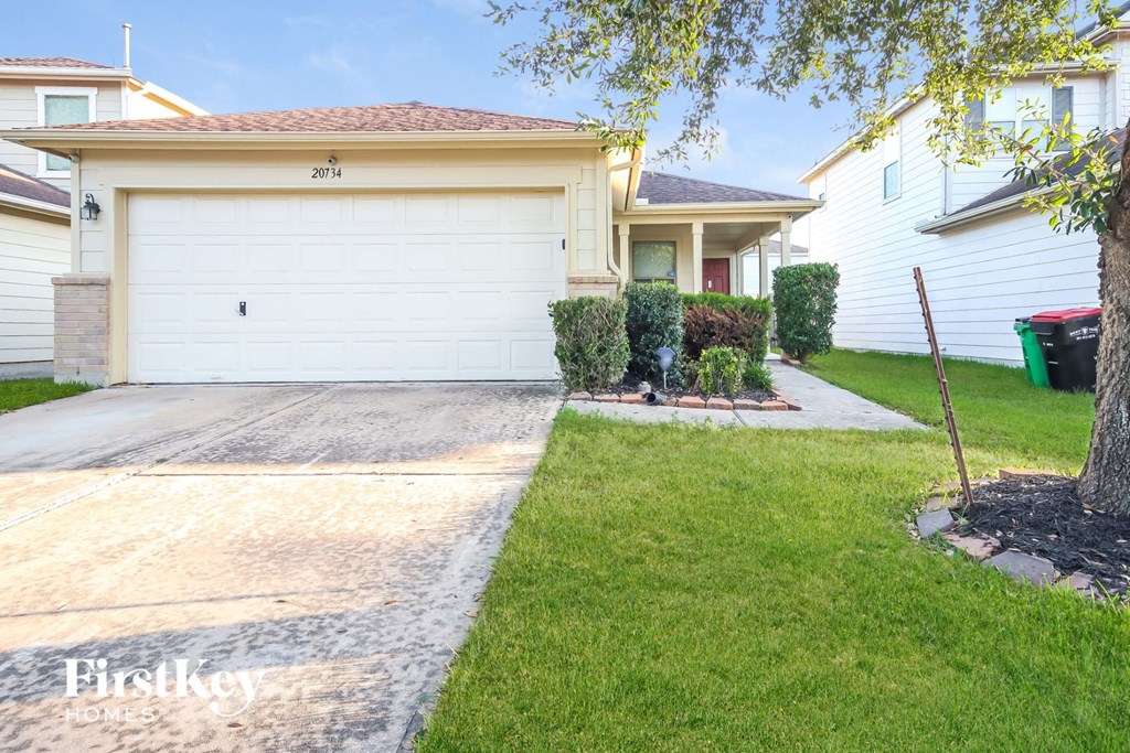 a home with a white garage door and a lawn