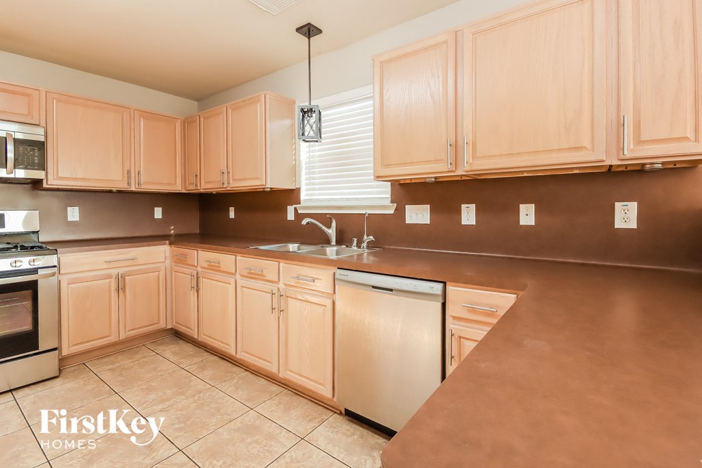 a kitchen with wooden cabinets and stainless steel appliances