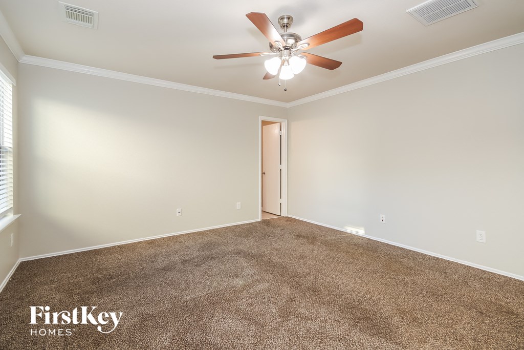 a living room with carpet and a ceiling fan