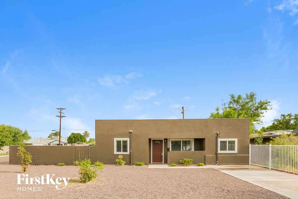 A house with a brown exterior and a gravel driveway.