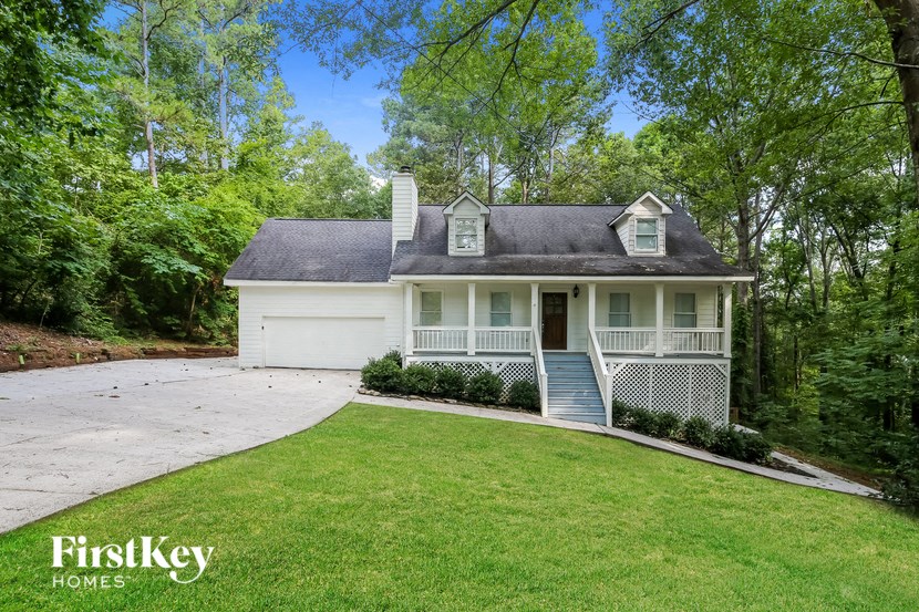a white house with a driveway and a lawn