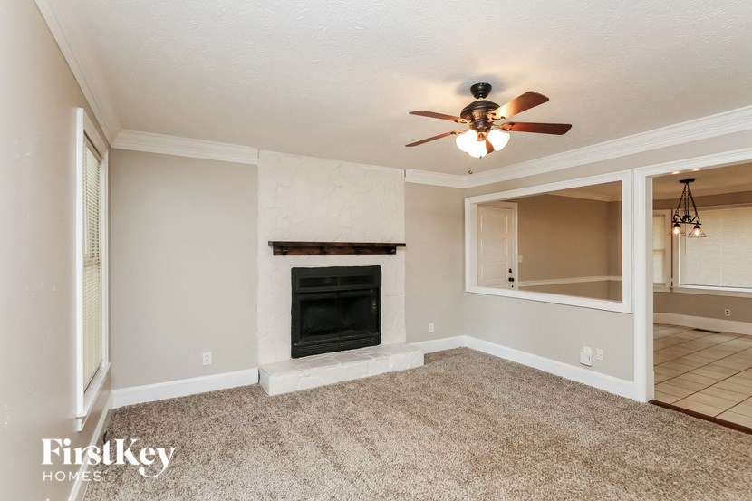 a living room with a fireplace and a ceiling fan