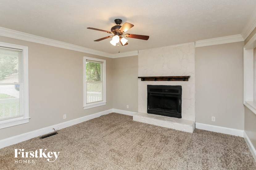 a living room with a fireplace and a ceiling fan