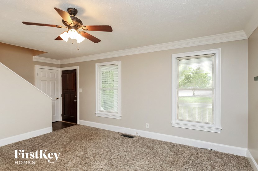 the bonus room has a ceiling fan and a carpeted floor