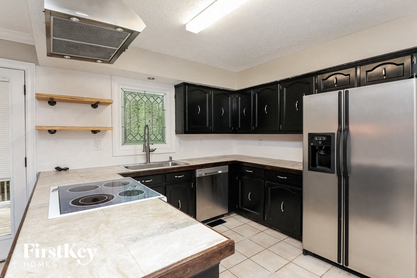 a kitchen with black cabinets and stainless steel appliances