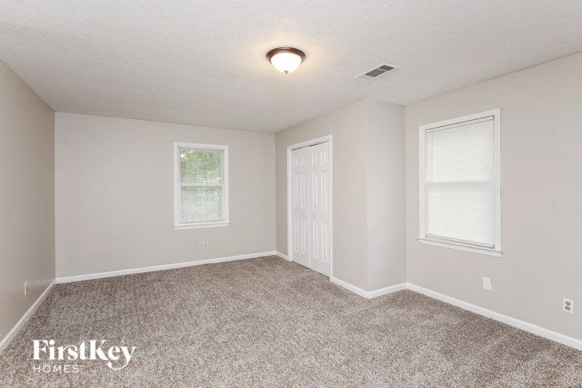 the spacious living room with carpeting and a white door