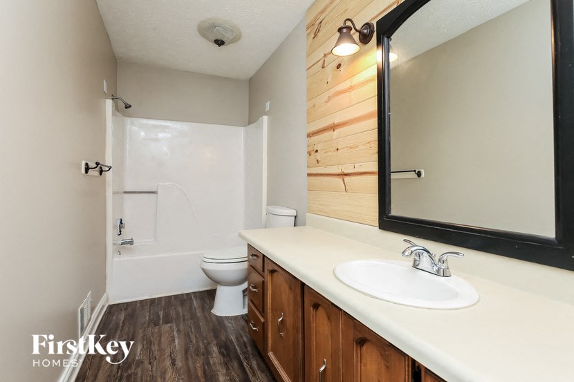 a bathroom with a toilet and a sink and a mirror