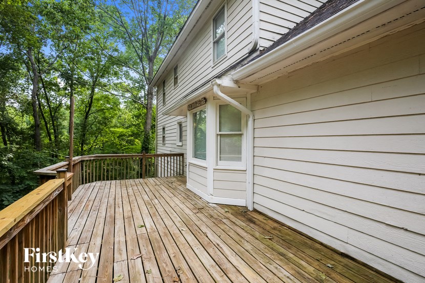 a deck on the side of a house with trees