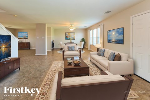 A living room with a couch, coffee table, and a painting on the wall.
