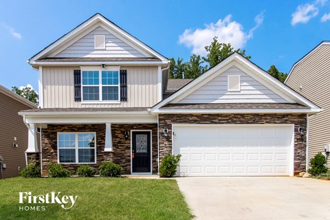 a home with a white garage door and a brick house