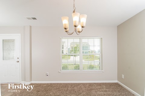 the living room of a home with a window and a chandelier