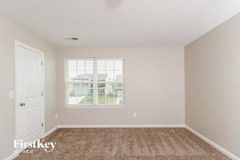 a bedroom with carpet and a window