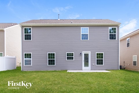 a gray house with white siding and green grass