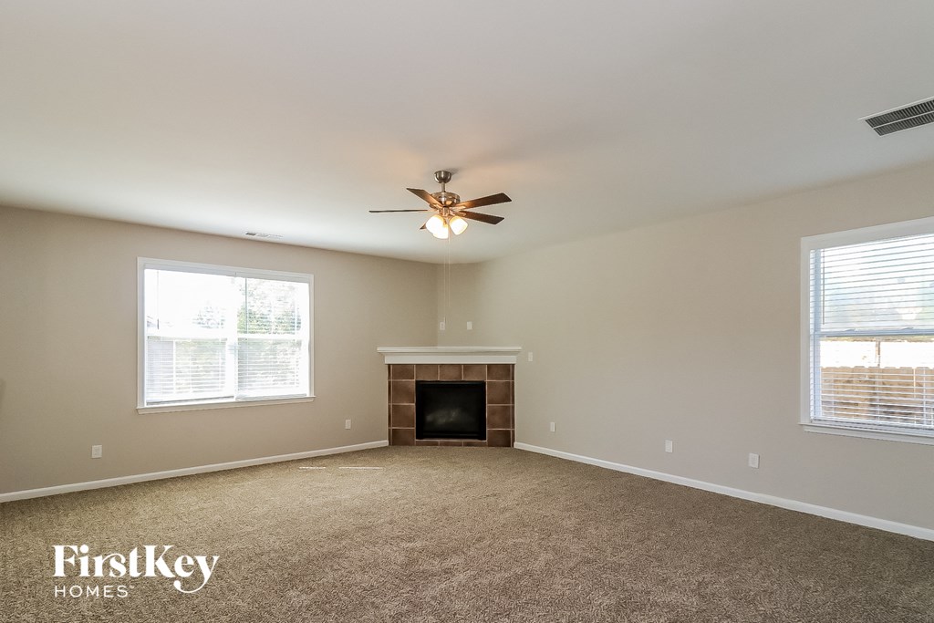a living room with a fireplace and a ceiling fan