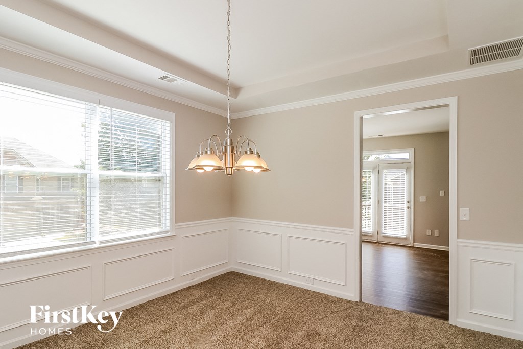 a dining room with a chandelier and a large window